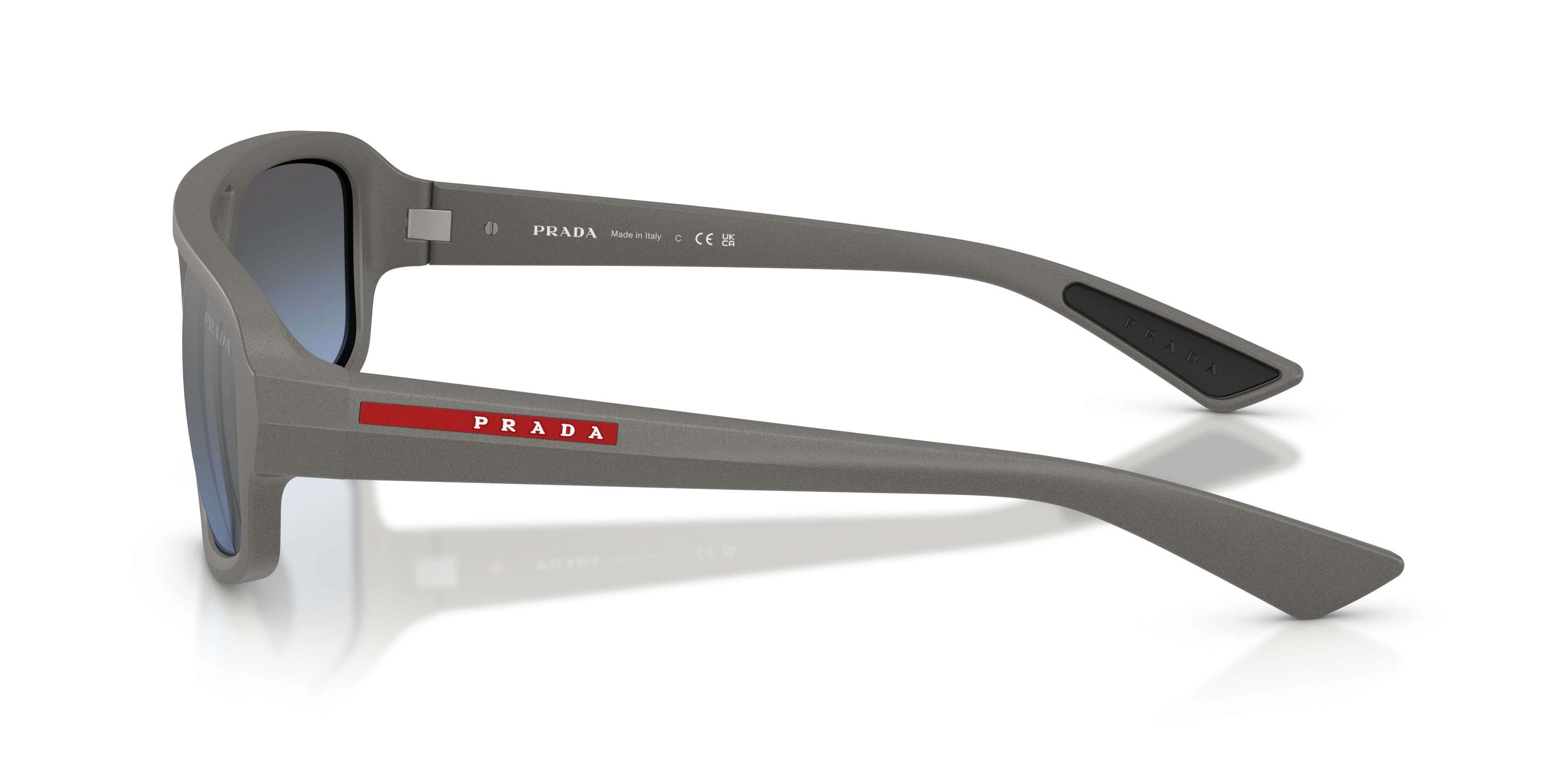 Occhiali da sole Prada Linea Rossa PS B11SU (16X11A) colore grigio metallizzato forma irregolare lenti celeste sfumato argento a specchio